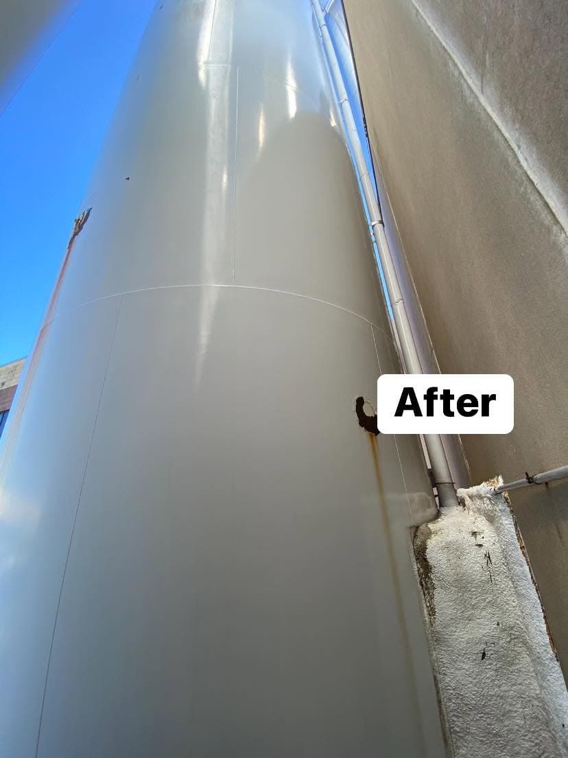 After restoration of a large vertical tank with clear sky in the background.
